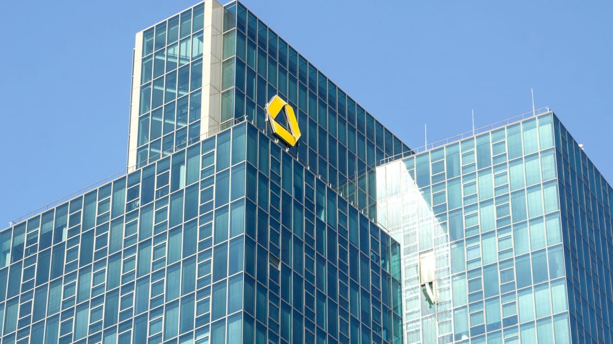 Türme der Commerzbank mit gelbem Logo vor blauem Himmel